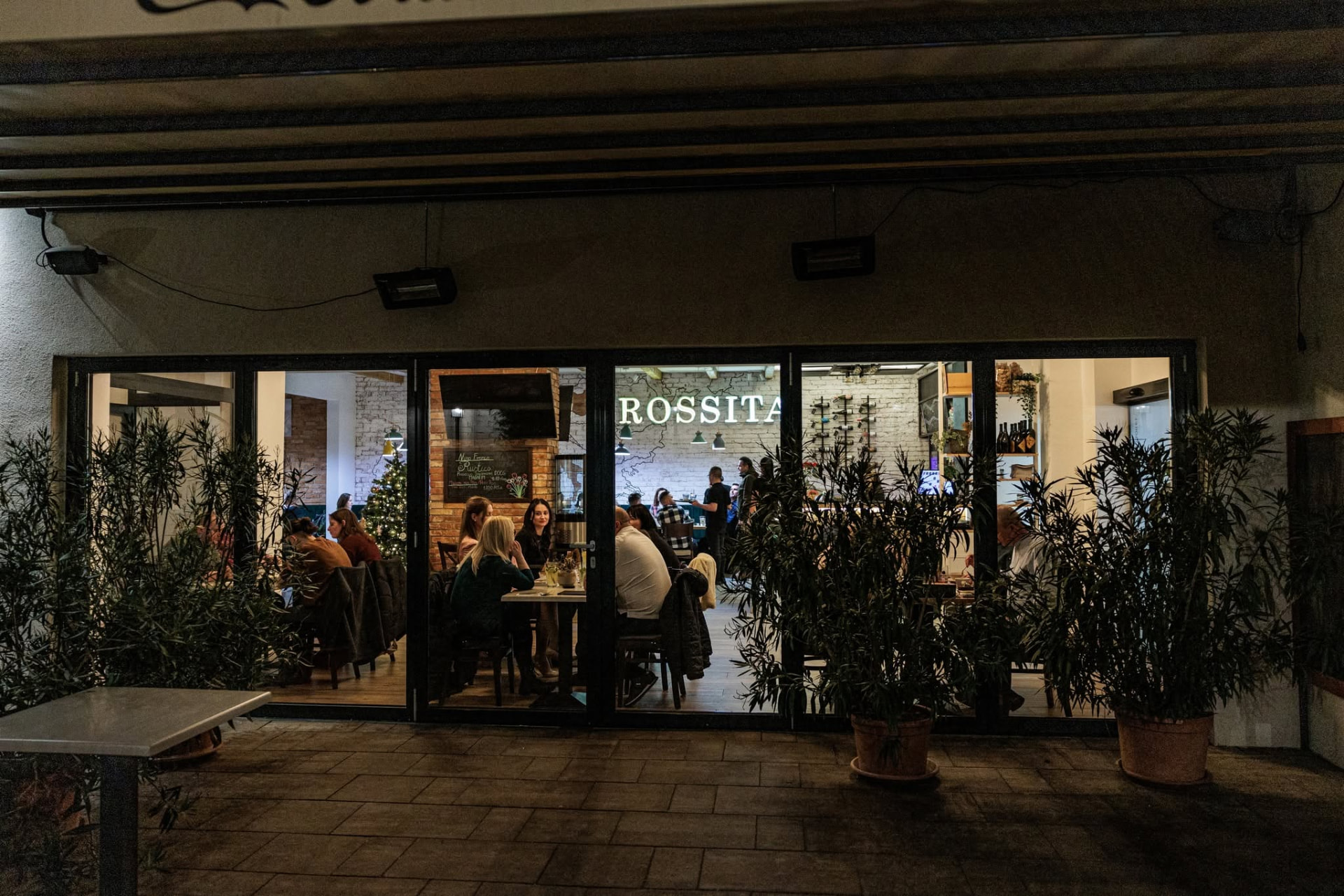 A Rossita Pizzéria hangulatos belső tere este a neonfelirattal